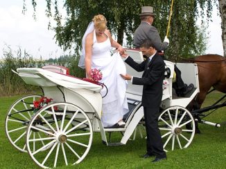 Brautpaar in einer Hochzeitskutsche